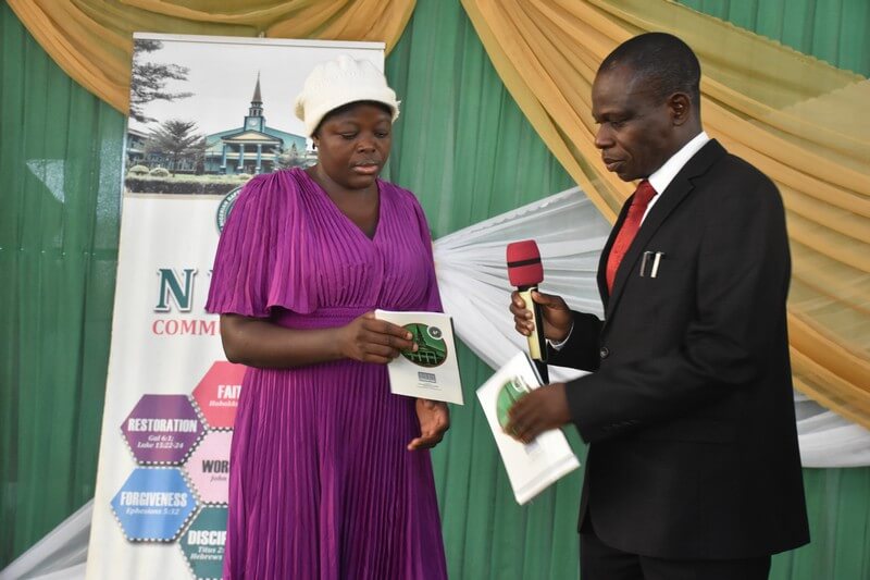 The registrar handing over the copy of the lecture to the Library representative